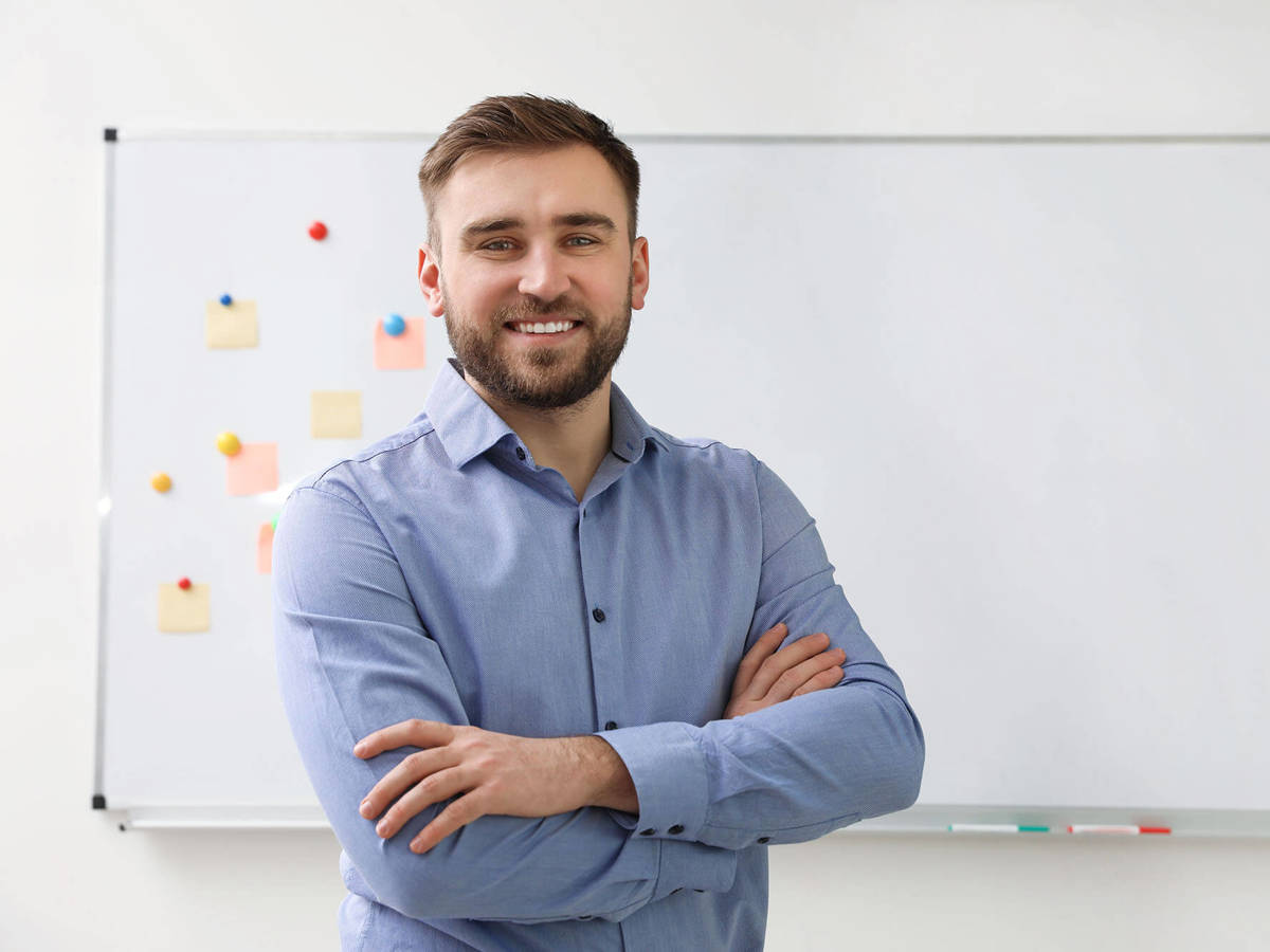 people man smiling in front of whiteboard