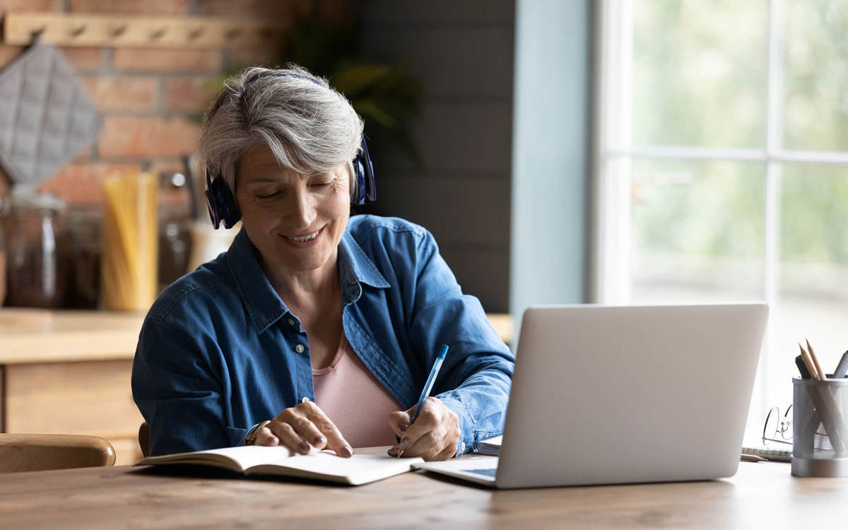 people woman writing notes off her laptop