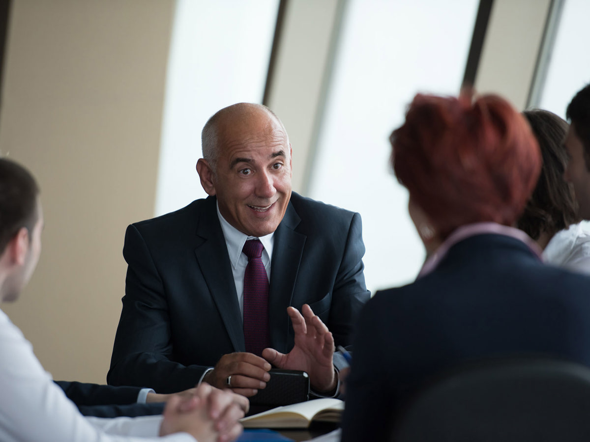training senior man discussing to a blurred group