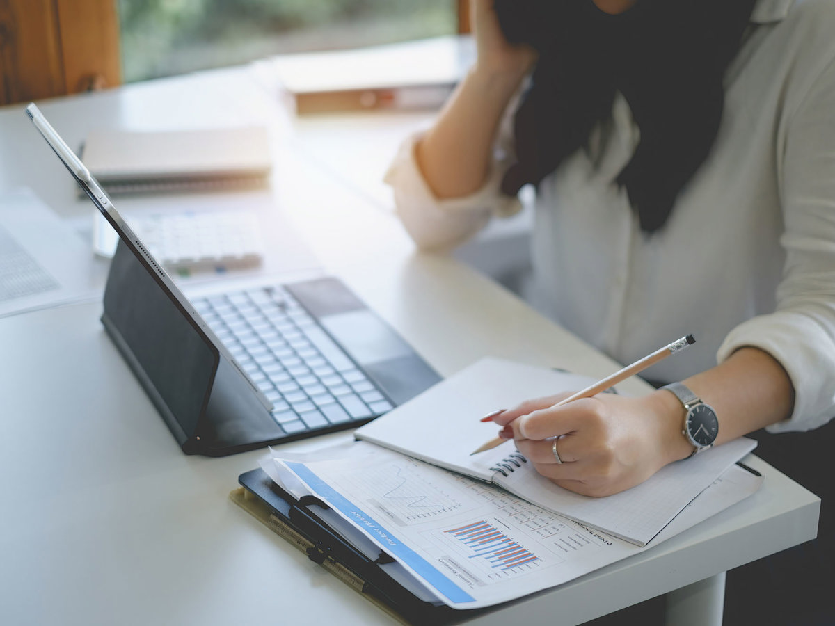 training woman writing notes off laptop
