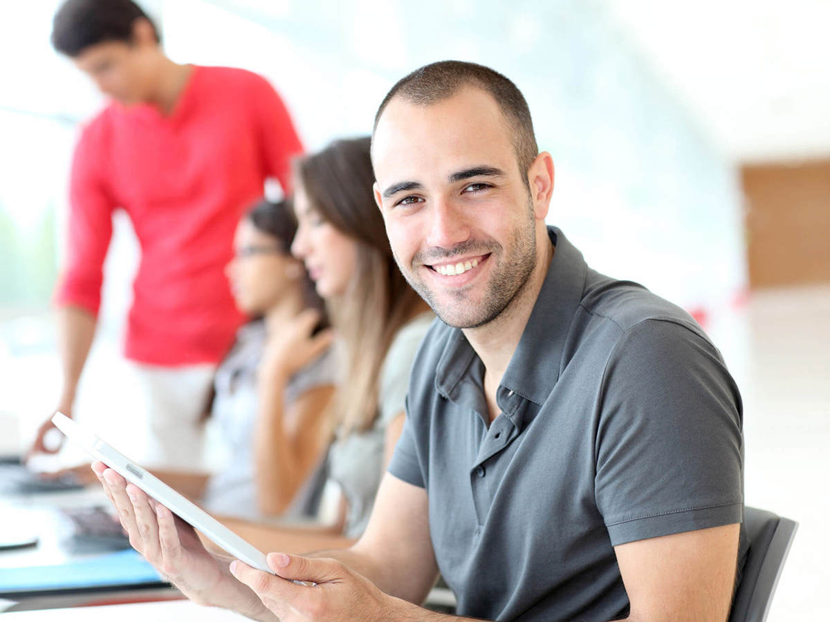 people in front of a line of computers with a man smiling
