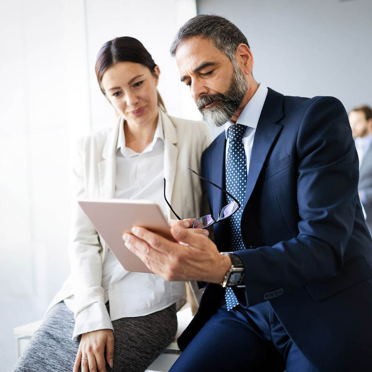 people two people reading off a tablet in a conference room