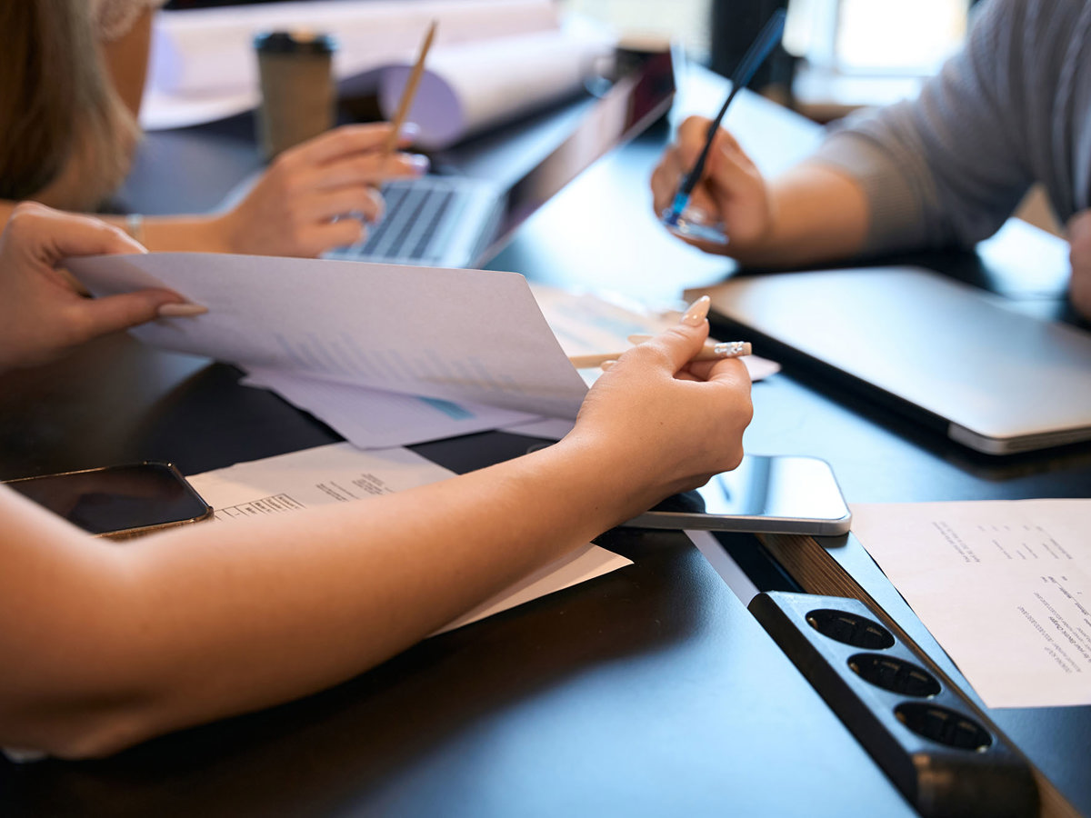 training three people at a tablet discussing notes