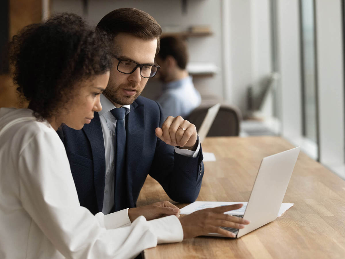 people man and a woman talking in front of their laptop